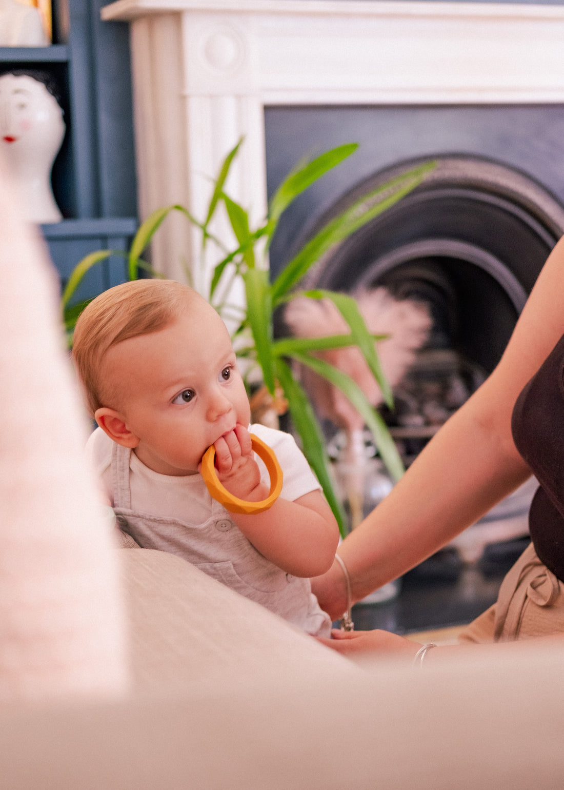 Baby chewing on a mango coloured bangle 